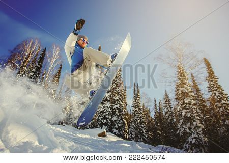 Snowboarder jumping through air with deep blue sky in background