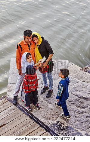 Isfahan, Iran - April 24, 2017: An Iranian family of four takes pictures of themselves on the Khaju bridge.