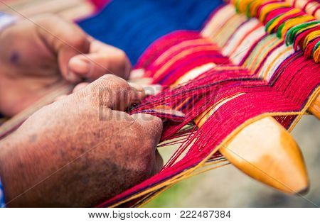 Woman hands weaving at a market in Peru