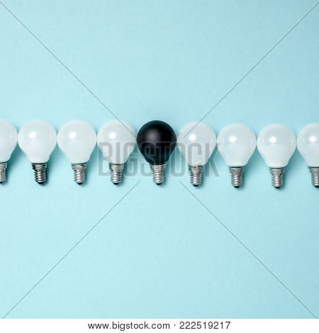 Creativity, creative thinking, ideas concept with electric lamps on blue background. The concept - not like everyone else or concept difference or individuality