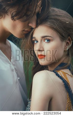 Young couple of elves in love standing in magical forest outdoor on nature. Close-up portrait. Fairy tale love, relationship and magic people concept. Man lovely ambracing woman