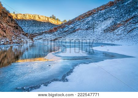 calm winter sunset over partially frozen Horsetooth Reservoir near Fort Collins in northern Colorado