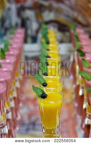 catring colored fruit mousse dessert in glass on mirror backgroung