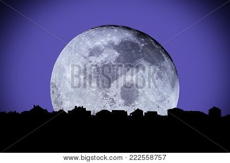 Moonlight over the suburbian roofs. Dark skyline in the backlighting with big moon. Element of this image are furnished by NASA.