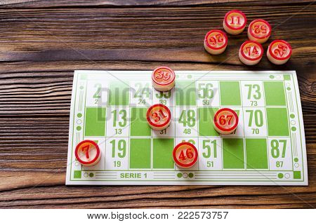 bingo  card with number balls on wooden table