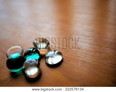 Clear and Green Blue Glass Beads on Wood Desk