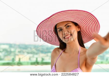 Swimsuit Concept. Beautiful girl wearing pink swimsuit. Beautiful girl in swimwear is relaxing at the swimming pool. Independent living sexy woman at the city center pool.
