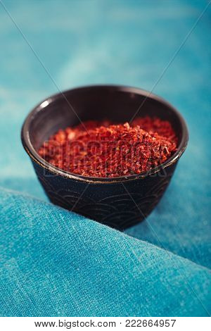 jalapeno smoked chili flakes in vintage mould tin on textured woden background