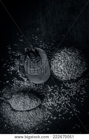 Cumin,Cuminum cyminum and powder 
and its extracted oil on wooden surface.