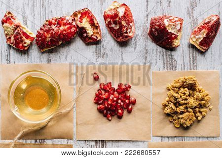 top view of pomegranates and honey for granola preparing on table