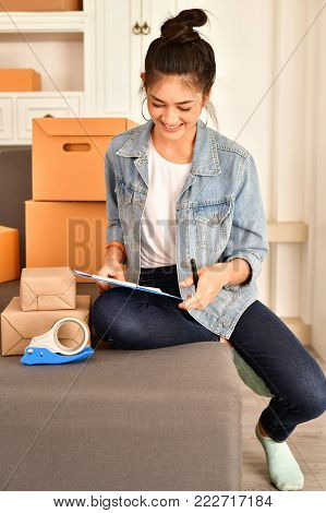 Sme business concept. Young Asian people are packing their packages.Delivery business  Small and Medium Enterprise (SMEs). Young man is working in the house.Young Owner Start up for Business Online.