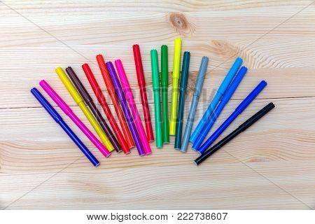 colored felt-tip pens on a wooden table