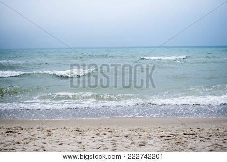 Calm tranquil blue sea with no waves and with foggy backgroudn