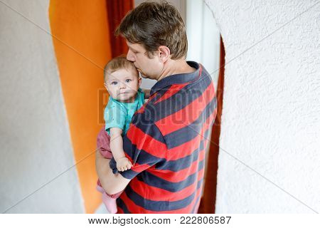 Happy proud young father having fun with newborn baby daughter, family portrait togehter. Dad with baby girl, love. Bonding, family, new life