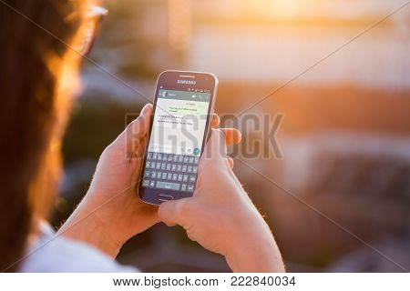 ROSARIO, ARGENTINA - NOVEMBER 8, 2017: Girl with smartphone in her hands and a whatsapp conversation on the screen. Young woman, millennial, chatting. Technology. Communications.