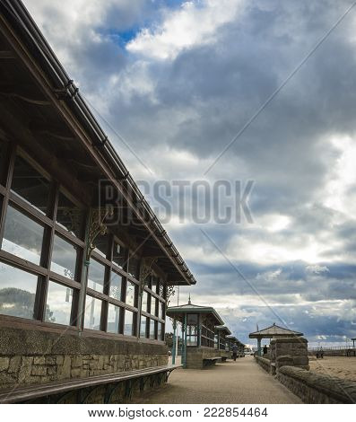 A series of seating areas along a beach on a cloudy day