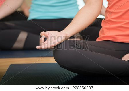 Young people praticing yoga indoors, hand close up with copy space, well being, wellness, healthy lifestyles
