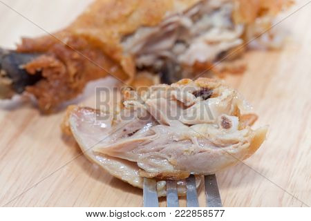fork and fried chicken on wooden board