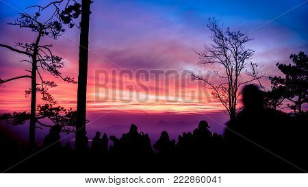 People watching Sunrise in the morning. Tourists travel relax in the holiday. photograph sunrise in the morning among people. Thailand