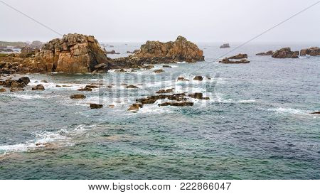 travel in France - view of rocky coastline of Gouffre gulf of English Channel near Plougrescant town of the Cotes-d'Armor department in Brittany in summer rainy day
