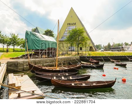 OSLO, NORWAY - JULY 27, 2013: Ancient wooden boats and sailing vessels in the Fram Museum harbor. Landmark of Oslo, Norway capital
