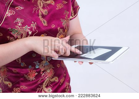 Young asian woman wearing chinese dress traditional cheongsam or qipao. Hands holding credit card and using laptop. Online shopping. Concept of buying digital online. on gray background.