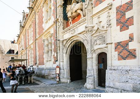 BLOIS, FRANCE - JULY 8, 2010: tourists near entrance to castle Chateau de Blois on square Place du Chateau. Blois is the capital of Loir-et-Cher department in central France