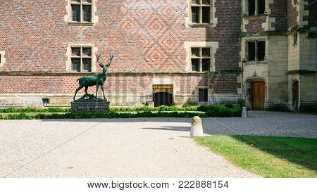 GIEN, FRANCE - JULY 9, 2010: deer statue in court of castle near museum in Chateau de Gien. Chateau was built in the XVth century for Anne of Franc, it was bombed in 1940 and later restored