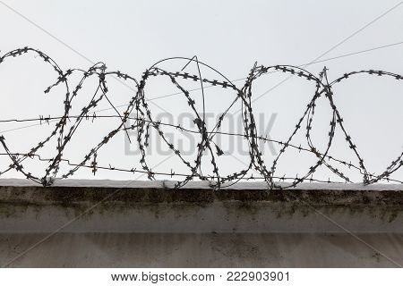 metal barbed wire on a concrete fence against the sky