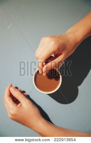 Young woman relaxing in hotel on brackfast with cup of coffee and macaroon.