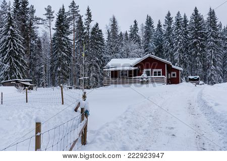 red wooden house in a snowy and cold varmland, sweden