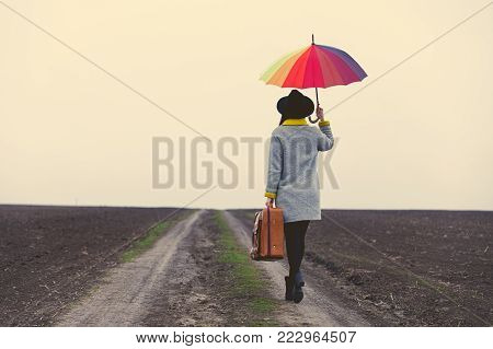 Girl In Black Coar Holding Suitcase At Countryside