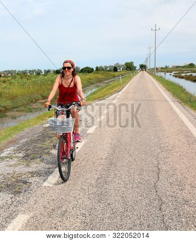 Pretty Woman On The Red Bike On The Road In Summer