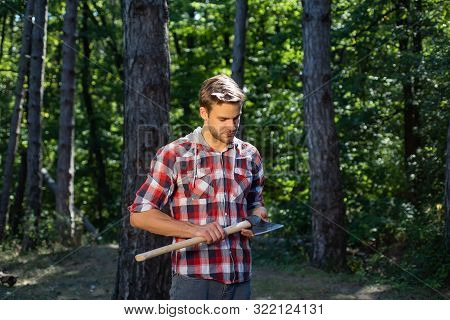 Lumberjack Standing With Axe On Forest Background. Deforestation Is A Major Cause Of Land Degradatio