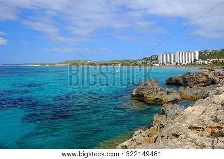 View On The Beach Son Bou, Amazing Water Colours And White Boat On The Balearic Island Menorca, Spai