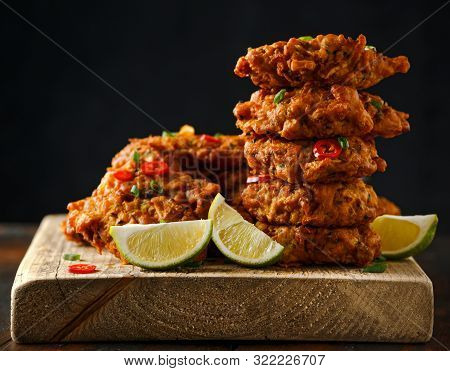 Indian Takeaway Food, Spicy Onion Bhajis Served With Chili Yoghurt Dip And Lime Wedges On Wooden Boa