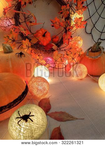 Halloween Decoration Of Pumpkins, Autumn Wreath With Yellow Leaves And Lights Garlands.