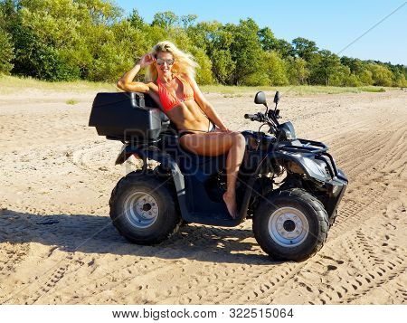 Attractive Woman In Bikini And Sunglasses With Long Blonde Hair Is Sitting On The Quad Bike, Sunny D