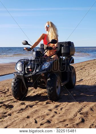 Attractive Woman In Bikini And Sunglasses With Long Blonde Hair Is Sitting On The Quad Bike, Sunny D