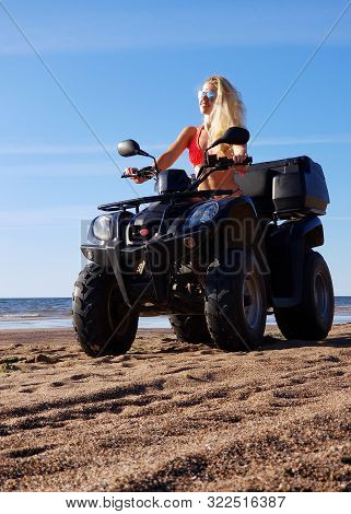 Attractive Woman In Bikini And Sunglasses With Long Blonde Hair Is Sitting On The Quad Bike, Sunny D