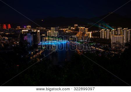 Night View Of Sanya City Illuminated With City Lights. View From Luhuitou Park On Hainan Island In C