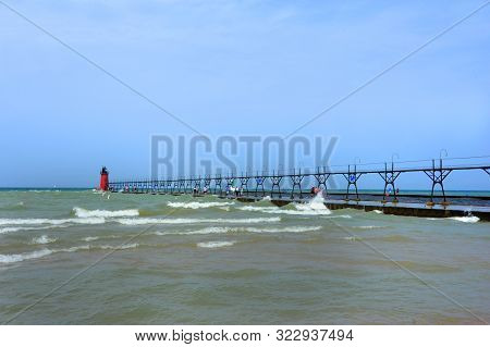 Long Pier Reaches Out Into Lake Michigan.  South Haven Lighthouse Sits At The End A Beacon For Shipp