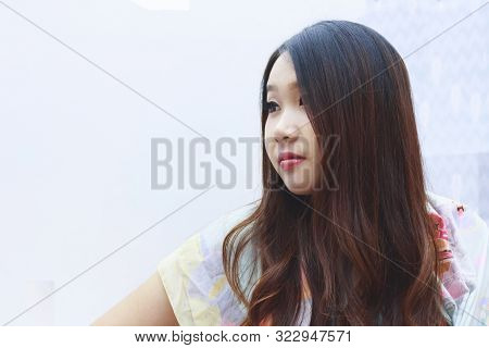 Beautiful Woman In Light Blue Spaghetti Strap Posing With White Background.