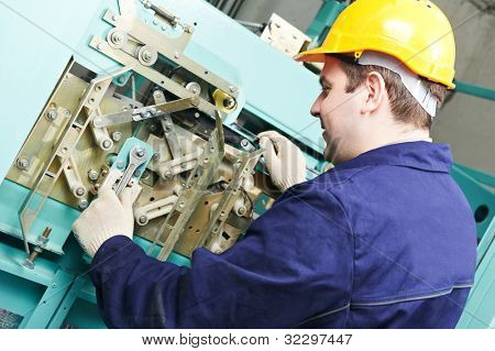 Ein Maschinist Arbeitnehmer bei der Arbeit anpassen-Aufzug-Mechanismus des Hebers mit anziehen