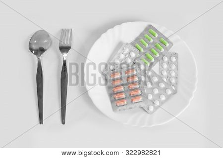 Different Pills On A Plate With Cutlery. The Concept Of Prescription Drugs For Weight Loss. Means Fo