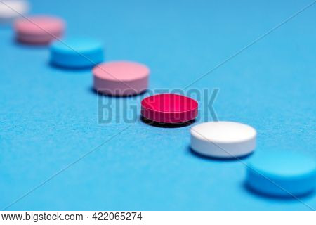 Medication Selection Concept. The Same Red Pill. A Row Of Pills, One Of Them In Focus.
