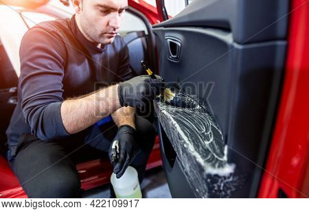 Car Service Worker Cleans Interiror With Special Brush