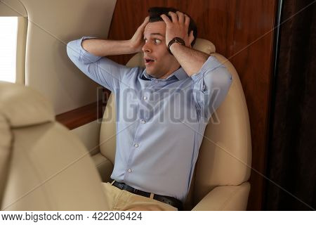 Scared Young Man Suffering From Aviophobia In Airplane