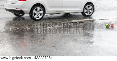 Raindrops Are Falling On A Street With A Moving Car And Toys