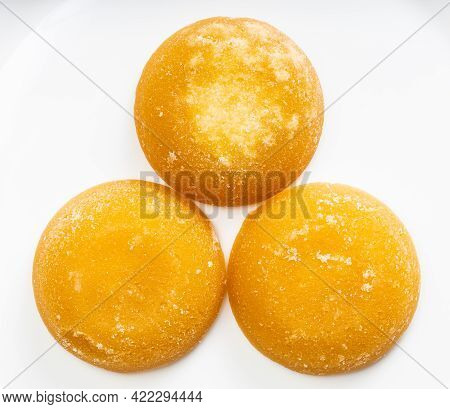Top View Of Few Whole Round Pieces Of Palm Sugar On Gray Ceramic Plate